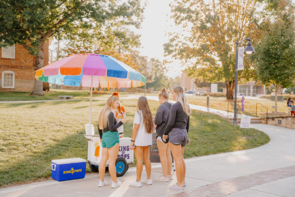 a group of people at a sidewalk stand