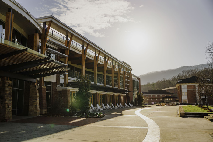 a building with a road and trees