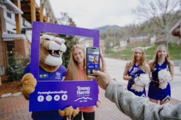 a person taking a selfie with a mascot