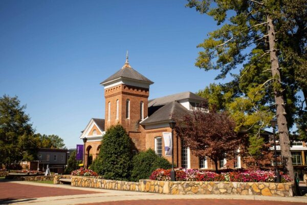 a large brick building with a steeple and a cross on top