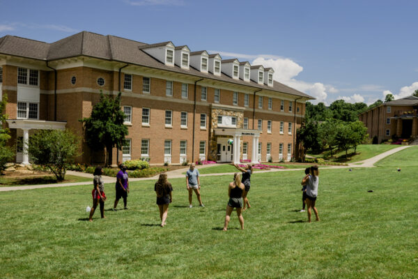 a group of people playing in front of a large building