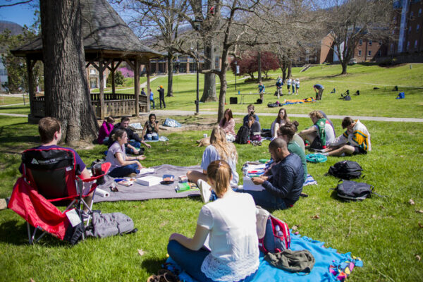 a group of people sitting on the grass