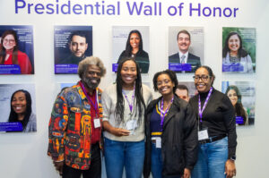 Group photo in front of wall of honor