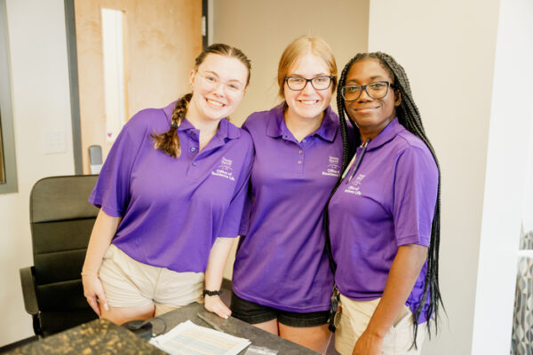 a group of women in purple shirts