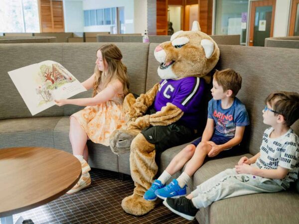 a person and a couple children sitting on a couch with a person in a garment