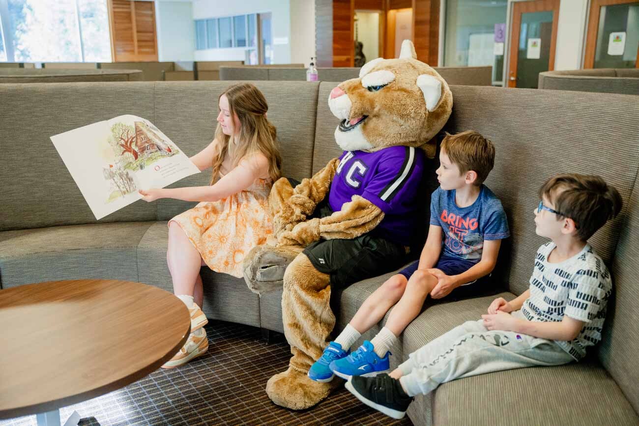 a person and a couple children sitting on a couch with a person in a garment