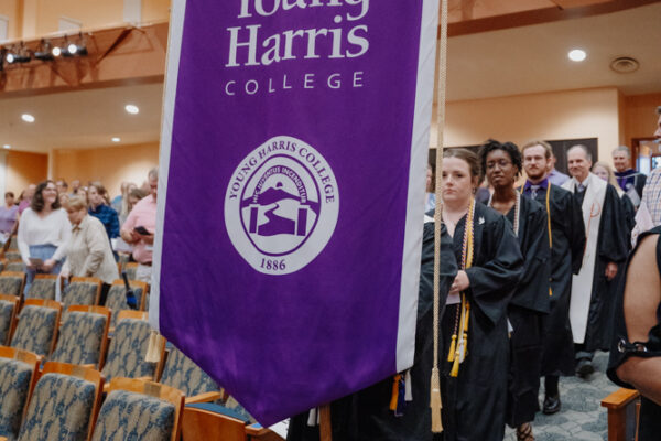 a group of people standing in a room with a purple banner