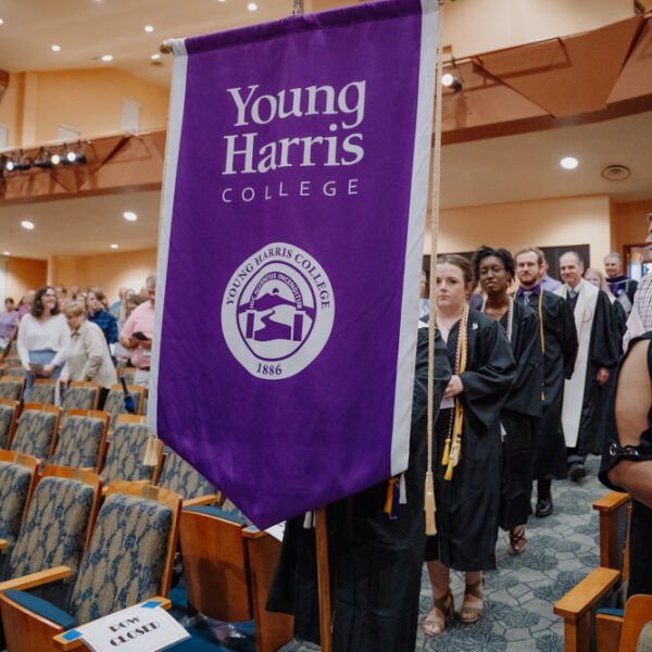 a group of people standing in a room with a purple banner