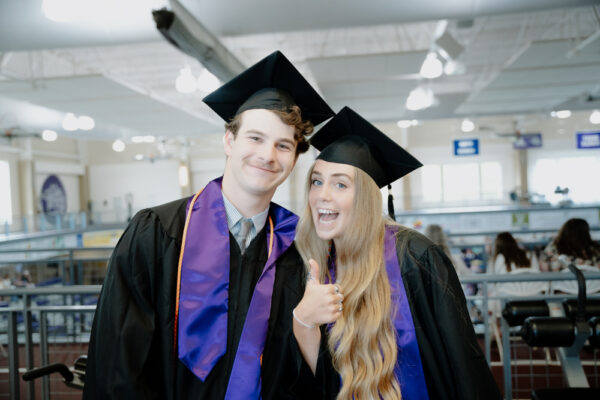 a man and woman wearing graduation gowns and caps