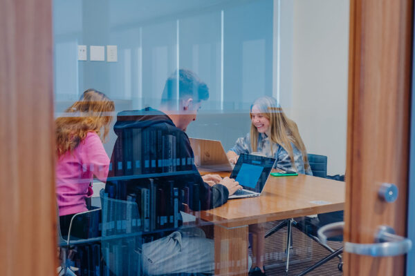 a group of people sitting at desks in a room