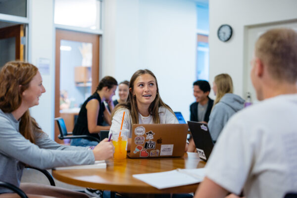 Students at table with laptop